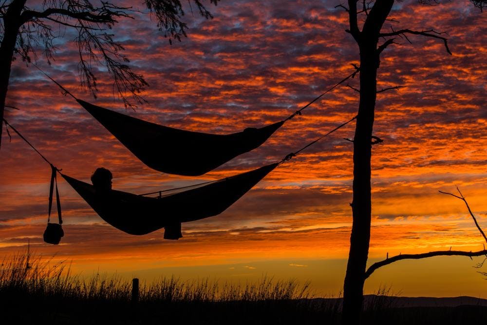 Person relaxing in front of a sunset